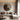 A large bronze round mirror with a minimalist frame hanging on the living room wall.