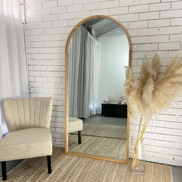 Wooden arch full length mirror in a bedroom