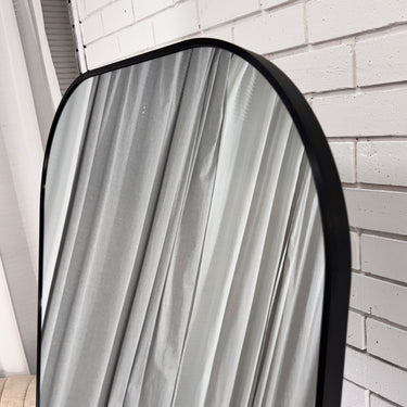 Freestanding arch mirror in a hallway
