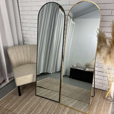 Simplistic arch mirror standing in a dressing area