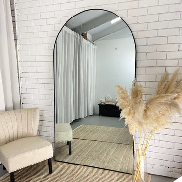 Extra large arch mirror in a living room interior