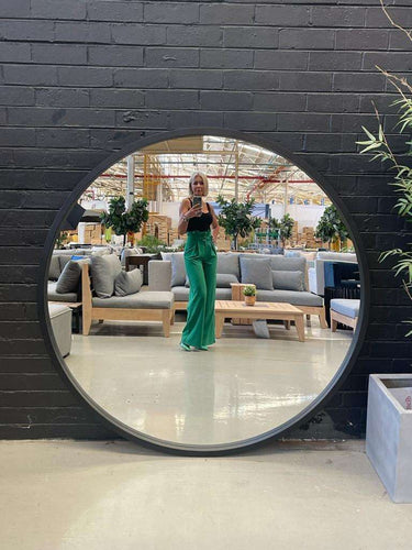 Large 120cm round wooden mirror on a wall