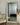 A white full-length mirror leaning against the wall in the bed room.