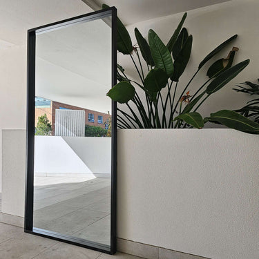 Real wood box mirror leaning against a wall