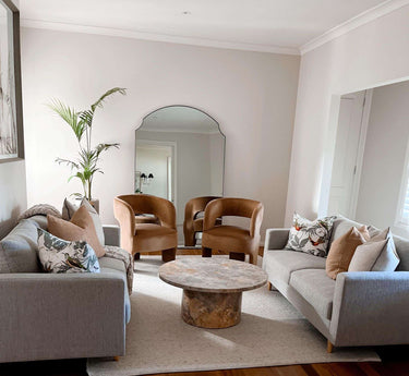 Extra large thin frame arch mirror leaning against a wall