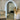 Luna backlit LED arch mirror in gold glowing on a wall