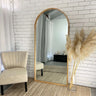 Wooden arch full length mirror in a bedroom