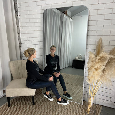 Thin frame full length mirror leaning against a wall