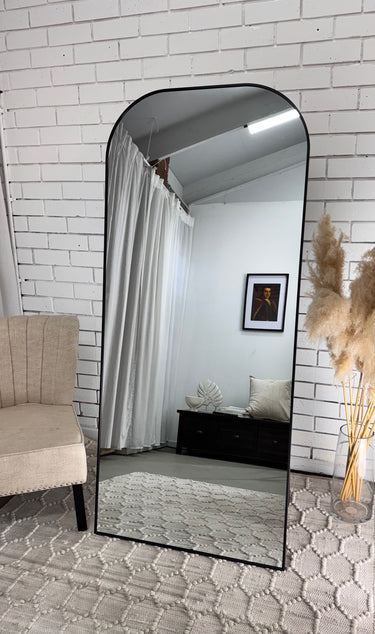 Freestanding rounded top arch mirror in a bedroom