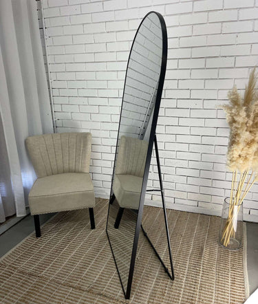 Gold freestanding arch floor mirror in a styled room