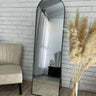 Black standing arch mirror in a dressing area