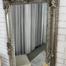 Ornate full length mirror with a carved wooden frame