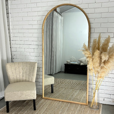 Light wood arch mirror in a coastal styled bedroom