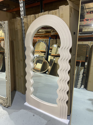 Off-white concrete-look mirror leaning in a room