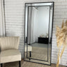Full length beaded leaning mirror in a living room