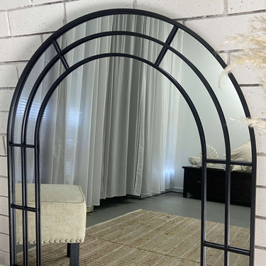 Small grid arch mirror above a console
