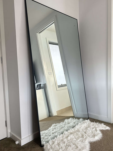 Thin frame full length mirror in a modern living room interior