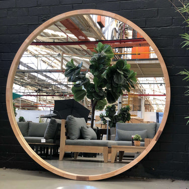 Large 150cm round wooden frame mirror on a wall