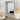Gold Grid Panel Mirror leaning against a white brick wall in a living room