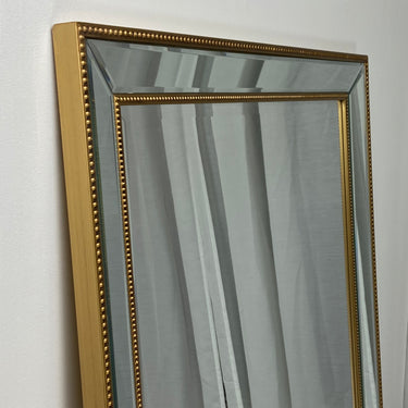Beaded rectangle wall mirror above a console table