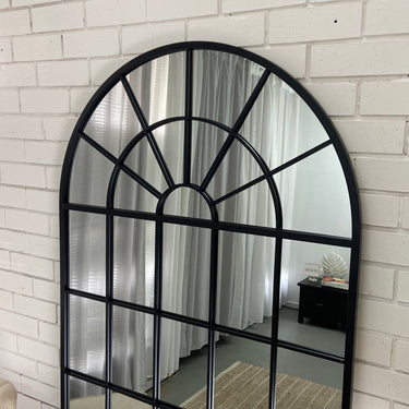 Arch grid window mirror leaning against a wall