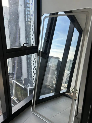 Curved LED full length mirror lit in a bedroom