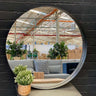 Round black metal mirror, 80cm, mounted on a wall